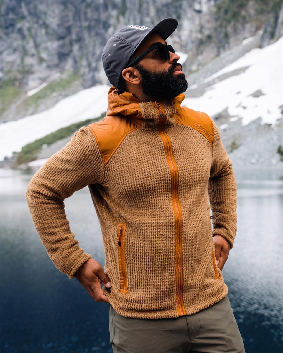 Man wearing the Alpha Aura Jacket  on a hike by an alpine lake.- Beyond Clothing USA
