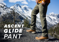 Hiker taking a break to enjoy the view of the mountain range while wearing the Ascent-Glide Pant.