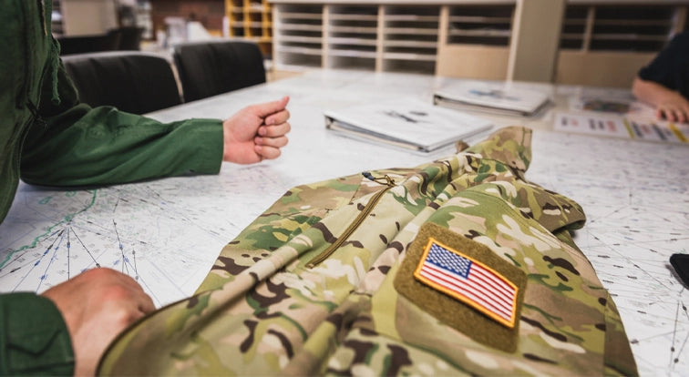 Camouflage jacket with American flag patch on a table