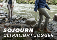 Two women wearing the Sojourn Ultralight Jogger while walking next to a river in the fall.