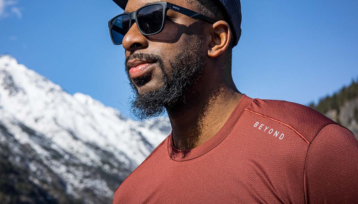 Man wearing Mars Red Geo T in the sun with mountain backdrop