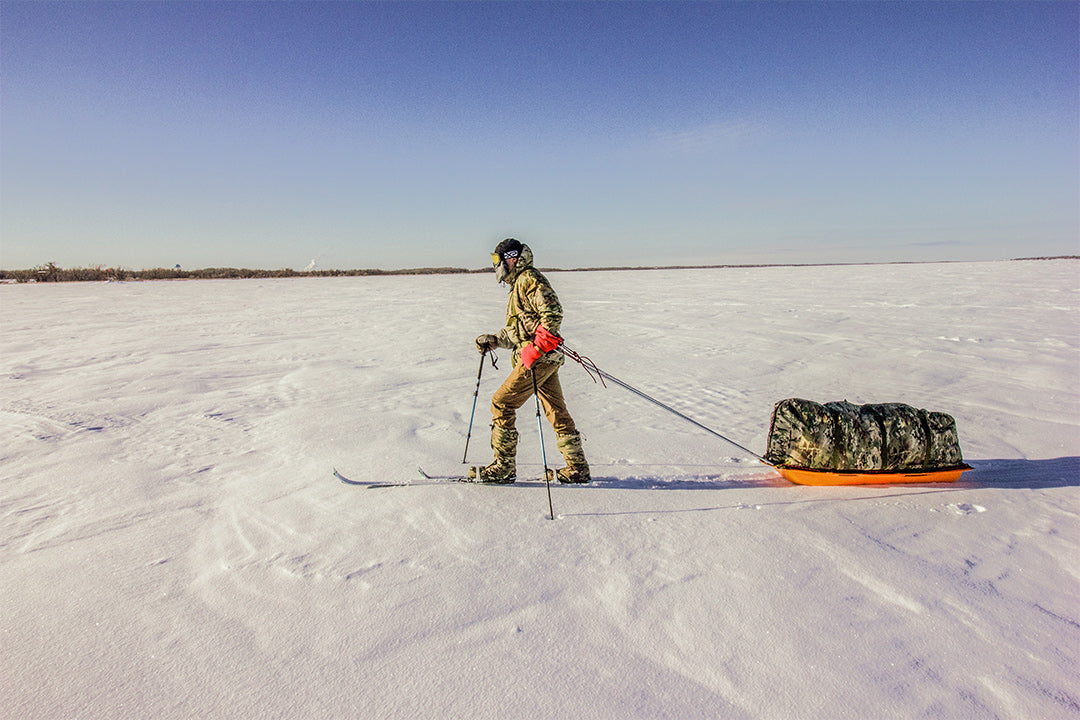 Arctic explorer cross country skiing while pulling a custom sled across the frozen Lake of the Woods, lake.