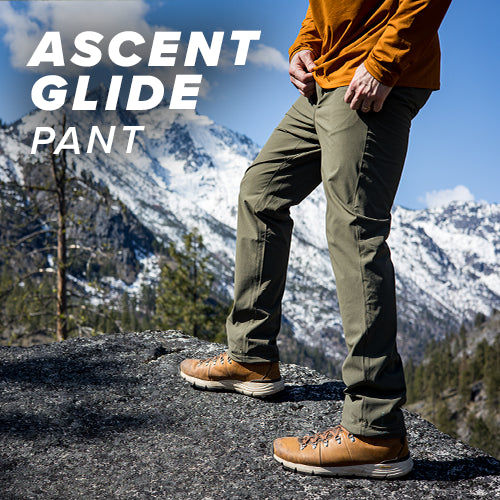 Hiker enjoying the view of the mountain range while wearing the Ascent-Glide Pants.