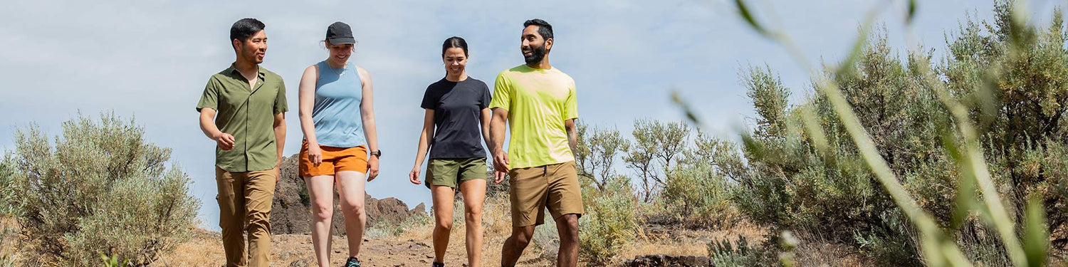 A group of friends is walking towards a climbing spot, all dressed in Beyond Clothing's summer 2024 collection.