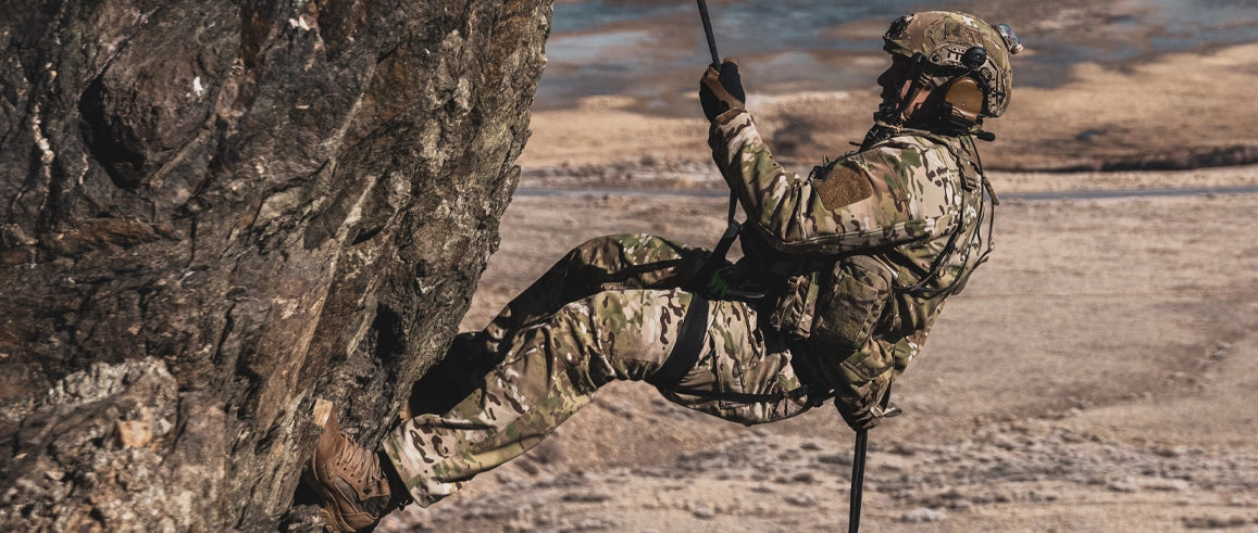 Person in camouflage climbing a tree in a natural setting