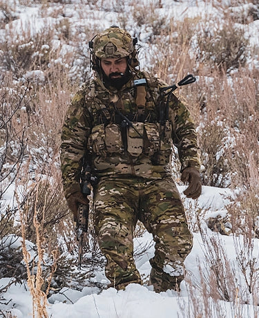 Man wearing the Operator collection from Beyond Clothing while walking down a mountain side.