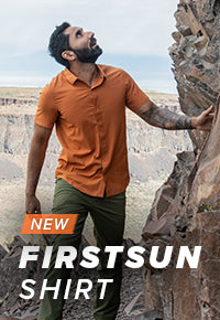 Man hiking and looking up while wearing the FirstSun Short Sleeve Shirt in the color Desert Clay.